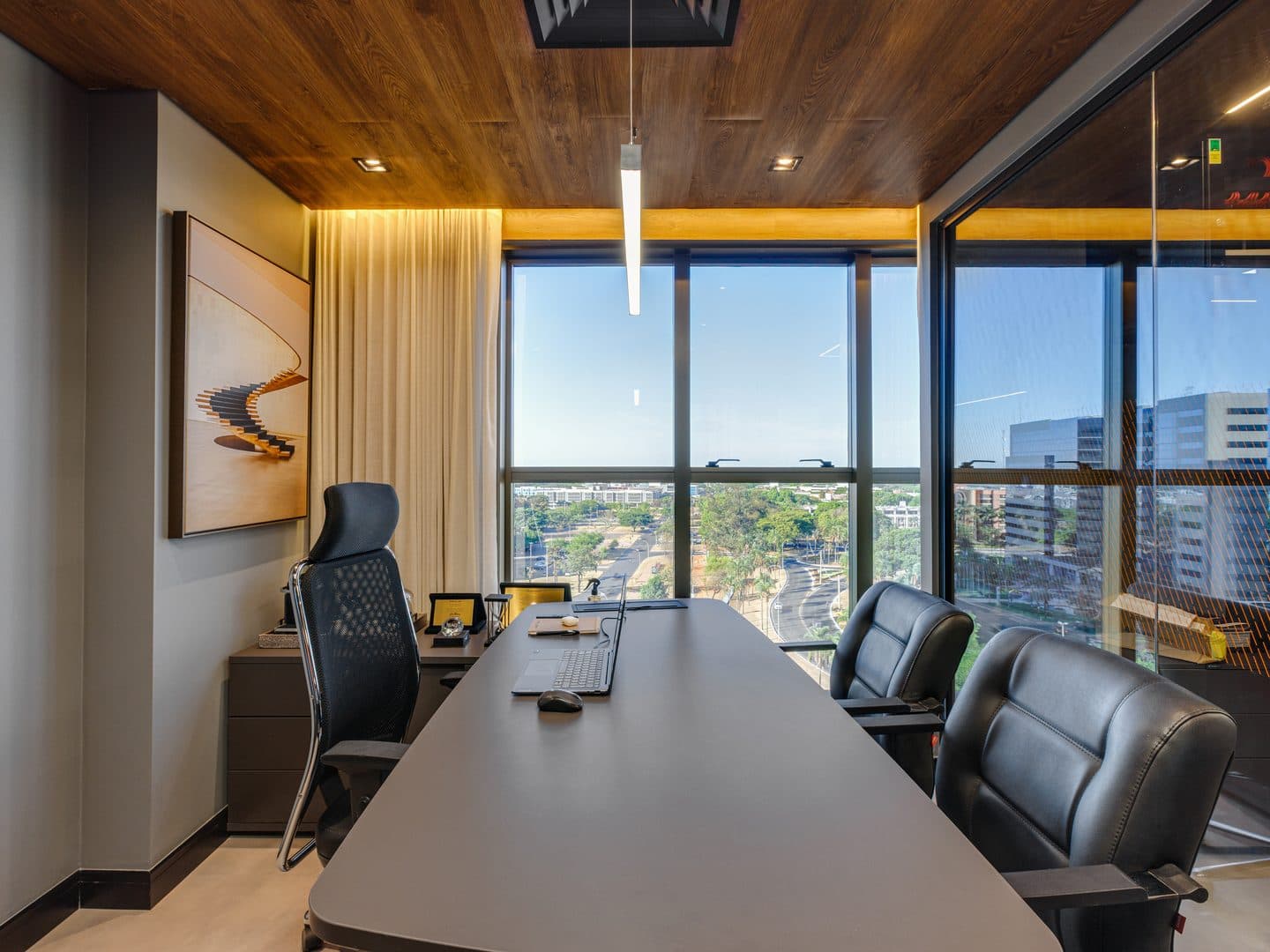 Sala de reunião com mesa longa e vista para a Asa Sul
